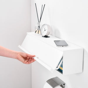 Baderom med hvit oppbevaringsboks festet over håndkleholder.