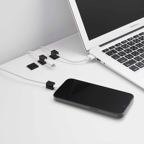 Sort kabelholder i silikon med selvklebende base til ladekabler