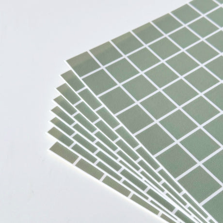 Stabel med grønne Teo fliser med hvite ruter klar til montering