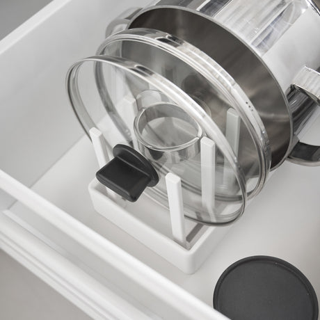 Justerbar lokkholder i hvitt materiale med gryter stablet side om side.