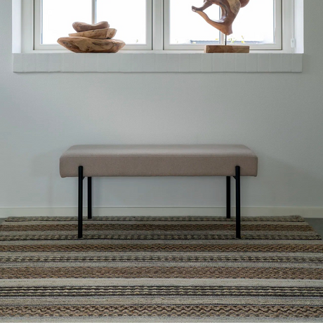 Steingrå benk med sorte metallben fra House Nordic, sett forfra mot hvit bakgrunn.