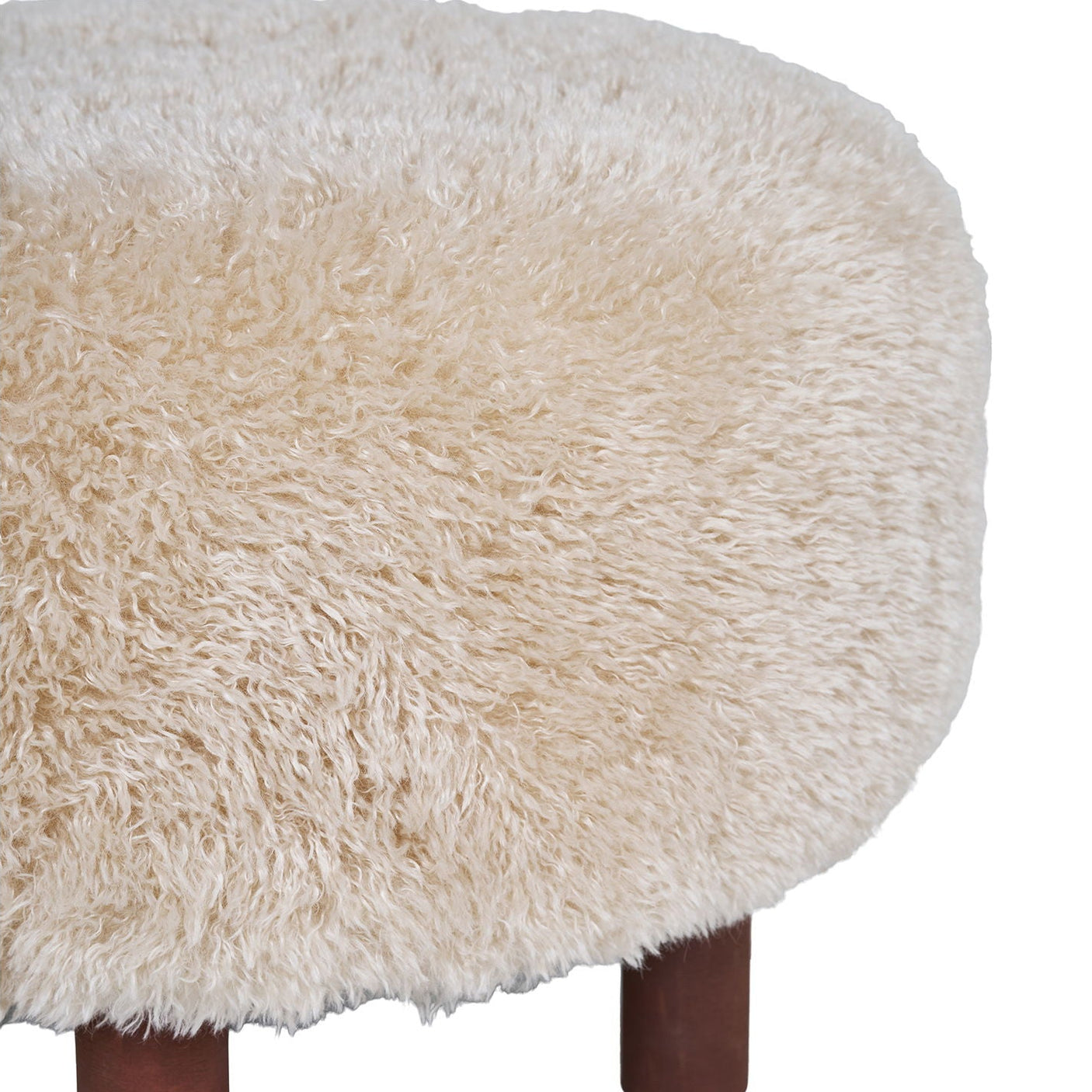 Rund puff med myk fuskepels og brune treben