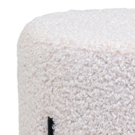 Rund puff med myk teddytekstur i lys farge og sorte ben