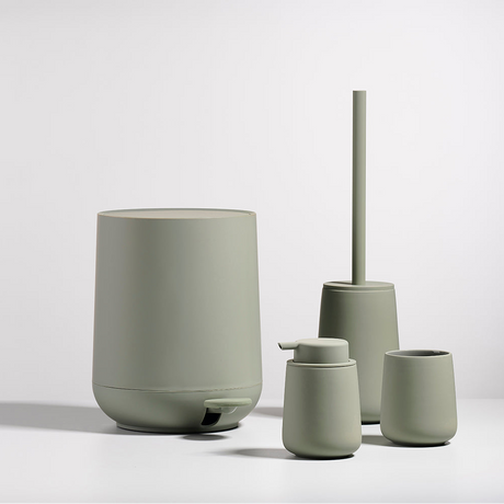 Toalettbørste i grønn tone som gir badet et rolig uttrykk