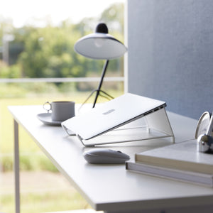 Hvit laptopstativ brukt i hjemmekontor med moderne innredning.