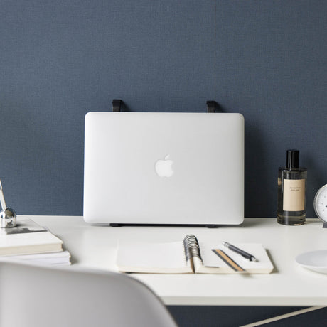 Sammenleggbart sort stativ for laptop på hjemmekontor.