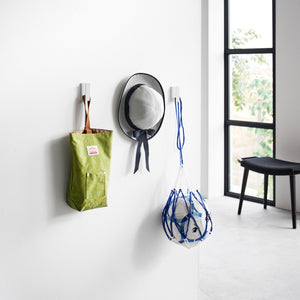 Kroker i hvit metall brukt som oppheng for gardiner i stue.