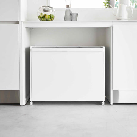 Kildesorteringsstativ hvit plassert under kjøkkenbenk i lyst kjøkken. Skjult