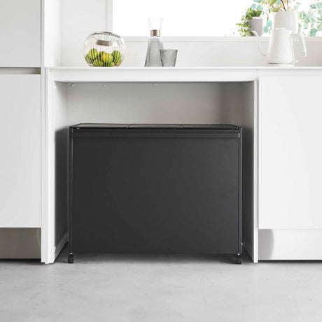 Kildesorteringssystem med hjul plassert under kjøkkenbenk i moderne kjøkken