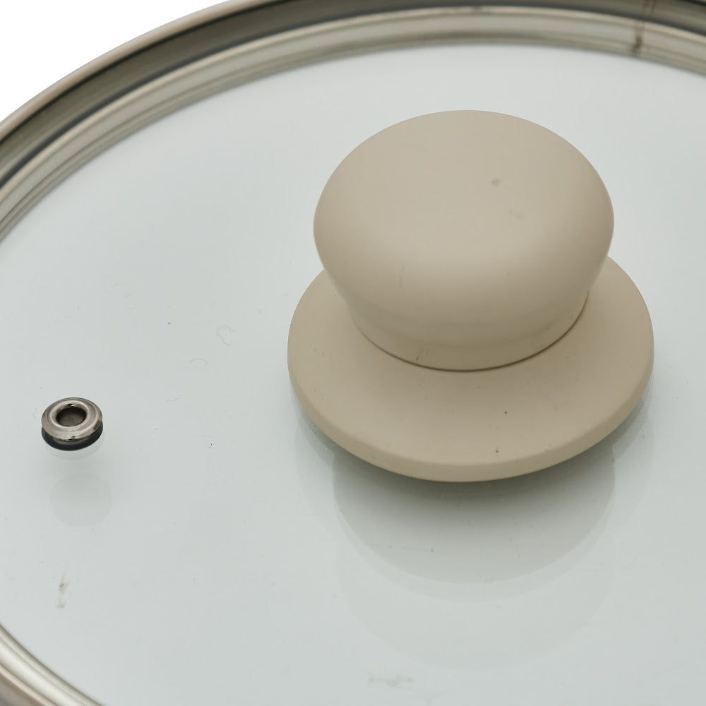 Nærbilde av glasslokk med beige knott