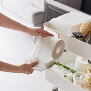 Person som bytter dorull på hvit magnetisk holder.