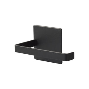 Sort magnetisk dorullholder montert på vaskemaskin på badet.