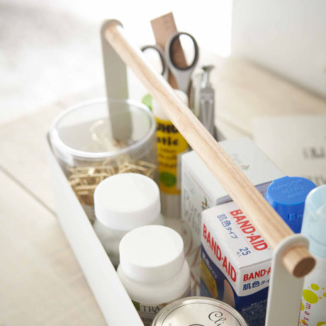 hvit oppbevaringsboks i stål med håndtak i tre