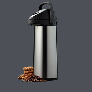 Pumpekanne servert med kaffebønner og kjeks mot mørk bakgrunn