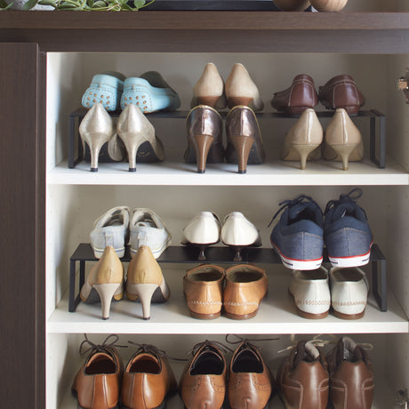 To sorte skohyller stablet med mange sko i gang