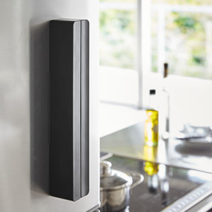 Sort folieholder med rull montert på kjøleskap.