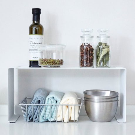 Hvit metallhylle som gir ekstra lagringsplass på kjøkkenet.