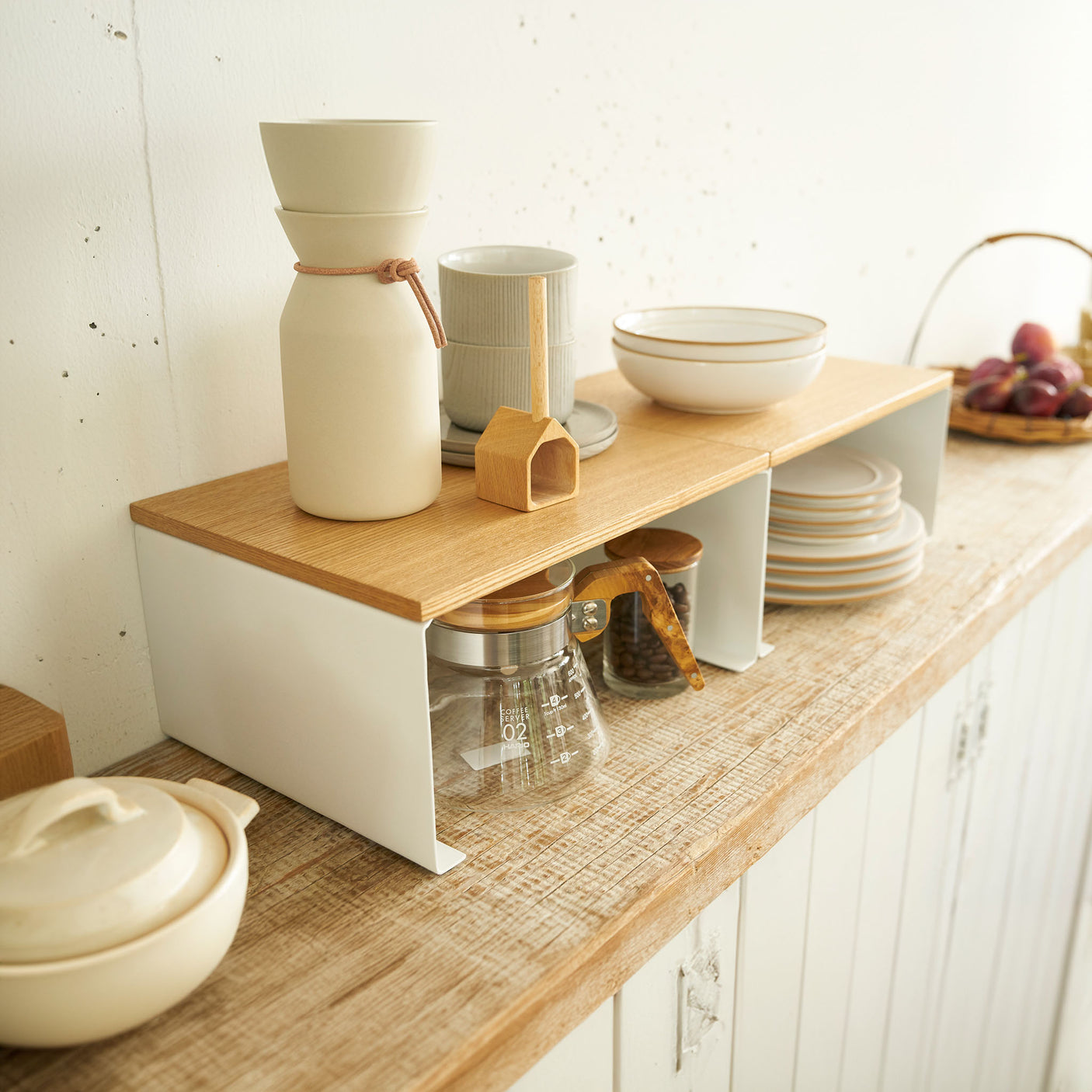 Hvit stabelhylle for oppbevaring av servise på kjøkkenet.