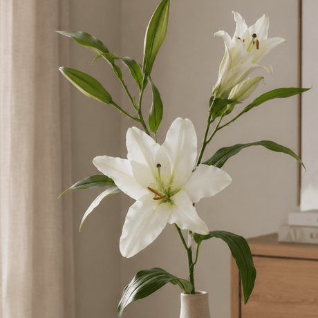Kunstlig hvid lilje med realistiske blomster og blade på grøn stilk. Nærbillede