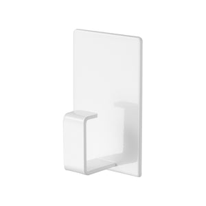 Hvit magnetisk krok montert på vaskemaskin med skittentøyskurv.