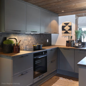 Kjøkken i Setesdal designet av Halvor Bakke med Hexagon mørk betong fliser fra Lindas Dekor og moderne, mørke fronter.