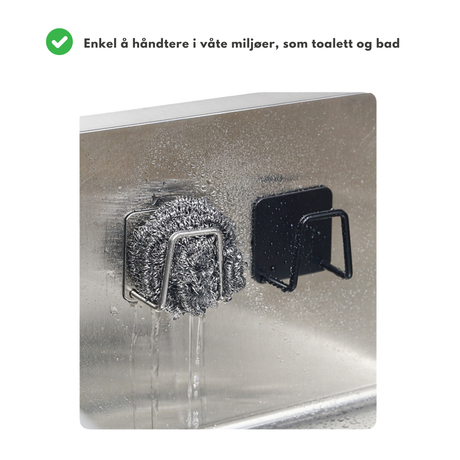 Knagg i rustfritt stål og svart finish festet inne i våt kjøkkenvask med stålsvamp.