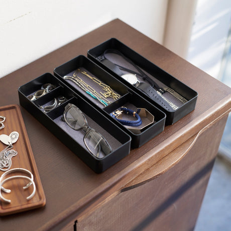 Sort tilbehørsboks med flere nivåer for organisering.