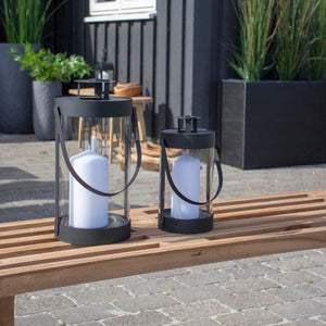 To sorte lanterner med kubbelys på terrasse