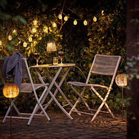 Bordlampe med solcelle og varm utebelysning på spisebord ute