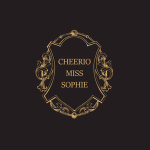 Nærbilde av sort serviett med gulltrykk "Cheerio Miss Sophie" og dekorativ ramme.