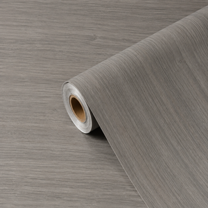 Rulle med Calm Greige kontaktplast, der viser naturtro gråbeige trefibere og mat finish
