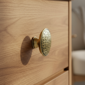 Knott i antikk bronse med dekorativt mønster på grønn bakgrunn fra Lindas Dekor