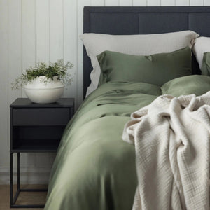 Grønt Borås Cotton Bliss sengesett på oppredd seng med beige pledd