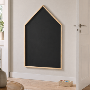 Husformet svart krittavle montert på vegg i lyst nordisk interiør med enkel og rolig styling.