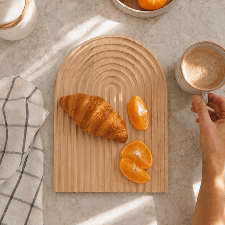 Rillet serveringsbrett i bøketre med croissanter og appelsinbåter, fotografert ovenfra ved siden av en kaffekopp. - Lindas dekor 