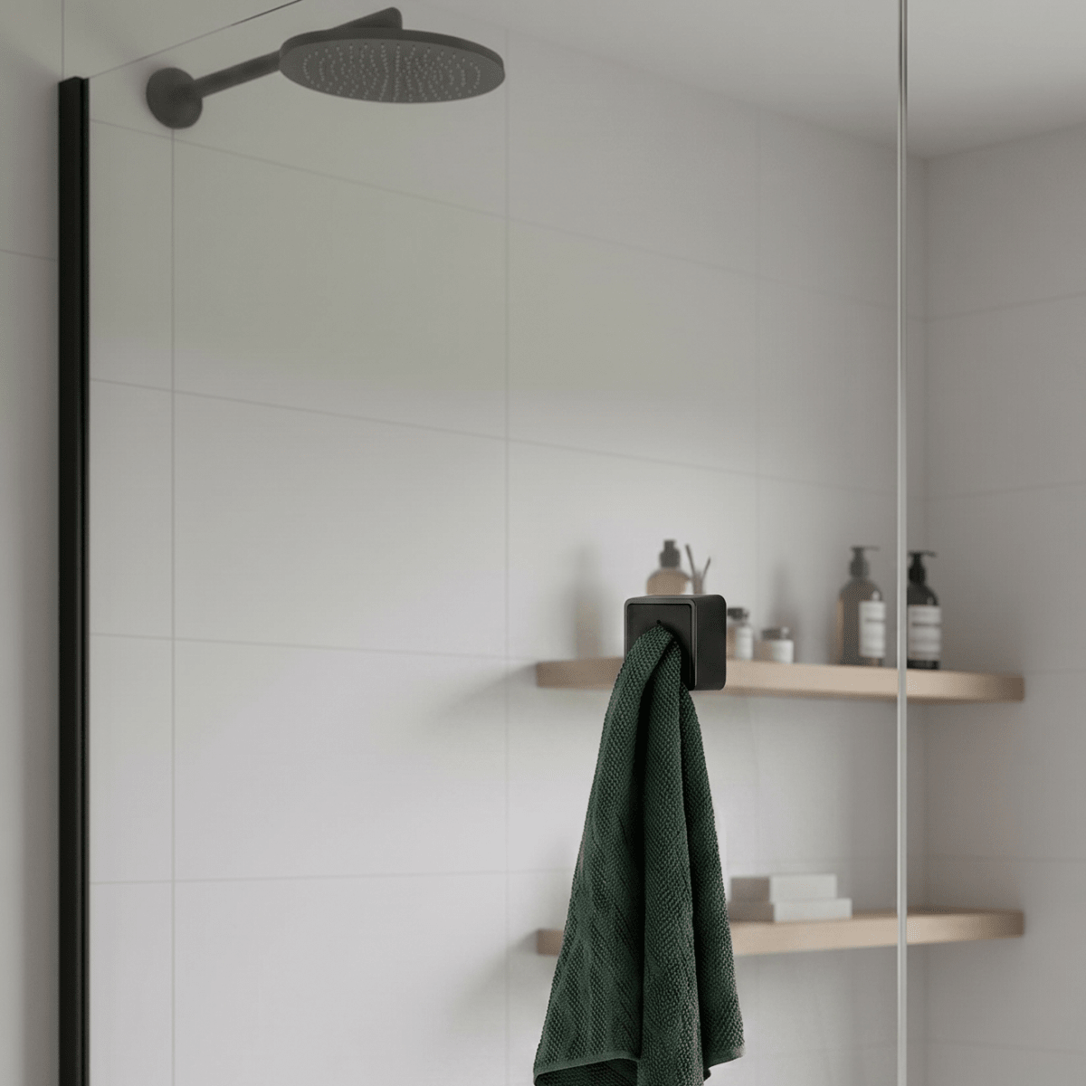 Sort selvklebende knagg brukt på bad med håndkle hengende ved dusj og hylle i moderne interiør. - Lindas dekor
