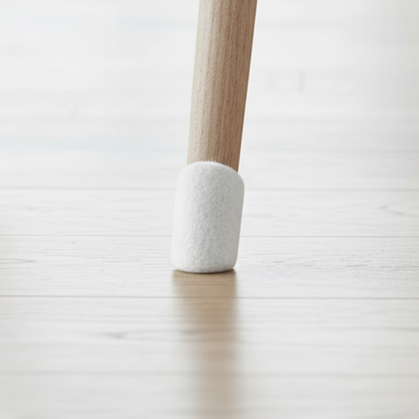 Hvit filtknott festet under stolbein på lyst gulv fra Lindas Dekor
