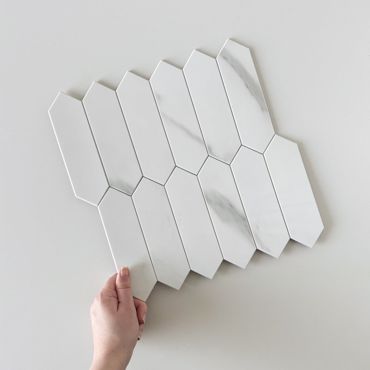 Caia lang hexagon selvklebende fliser er perfekte for å skape et tidløst og luksuriøst design for kjøkkenet. Designet er i klassisk marmor i et avlangt hexagonalt mønster.  