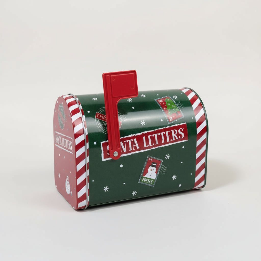 Grønn metallpostkasse med julemotiv brukt som dekor foran juletre