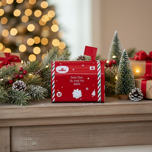 Rød julepostkasse i metall foran juletre – liten dekor til jul fra Lindas Dekor