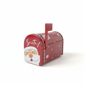 Liten rød og grønn postkasse med julemotiv brukt som pynt på bord ved juletre