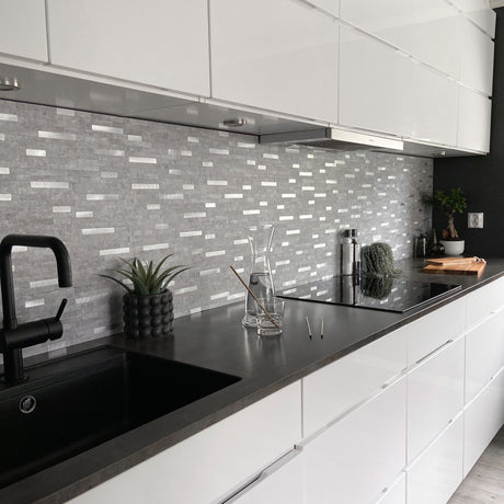 Fliser i delikate gråtoner gir veggen dybde og karakter.