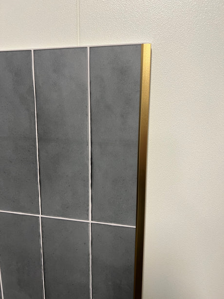 taljbilde av messingfargede endelister montert på selvklebende flise