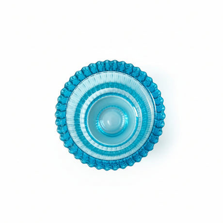 blå lysestake i glass med riflet overflate