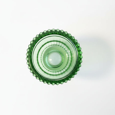 grønn lysestake i glass med riflet overflate