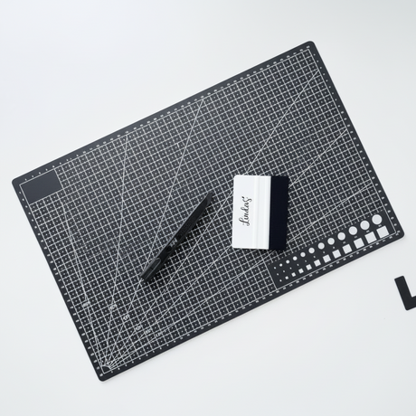 Skjærematte A3 med rutenett foliesletter og tapetkniv brukt til å kutte og glatte kontaktplast.

