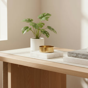 Lysestake i hvit marmor med gullfarget holder på lys trebord