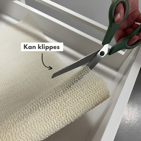 Tilpasning av skuffematte med saks for perfekt passform i kjøkkenskuff.