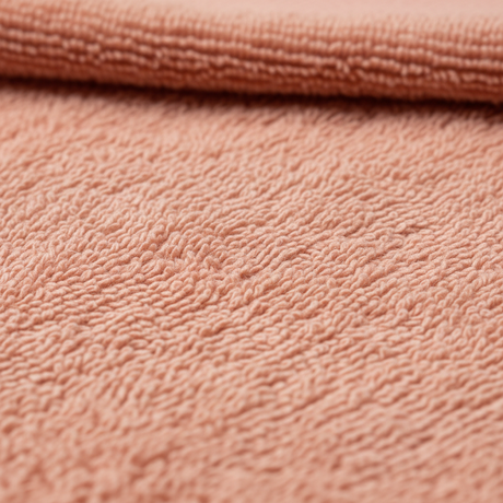 Mykt badehåndkle i rosa hengende i moderne baderom