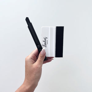 Verktøypakke i bruk på kjøkkenbenk til å montere kontaktplast og fliseklistremerker presist.

